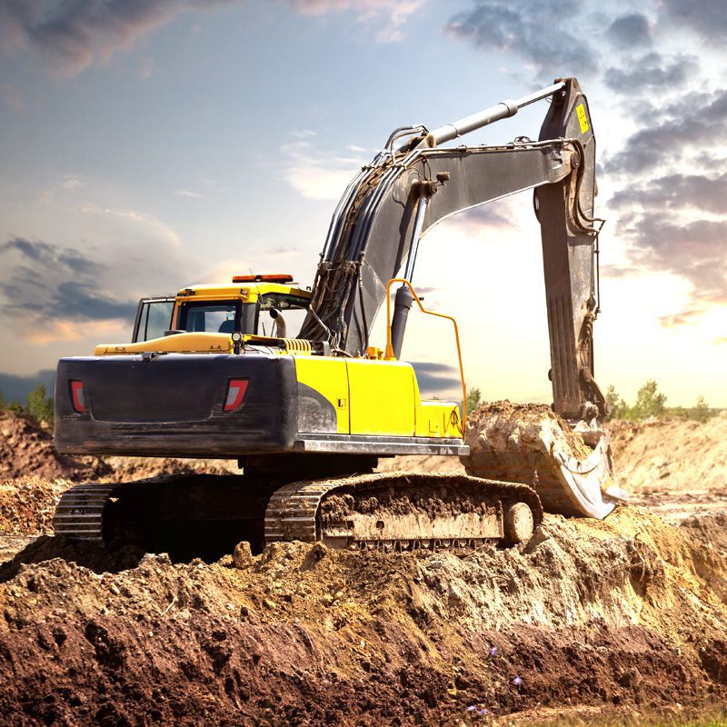 Contractors Resource | Early Branch, SC | Yellow backhoe digging up dirt against a dark sky in the background