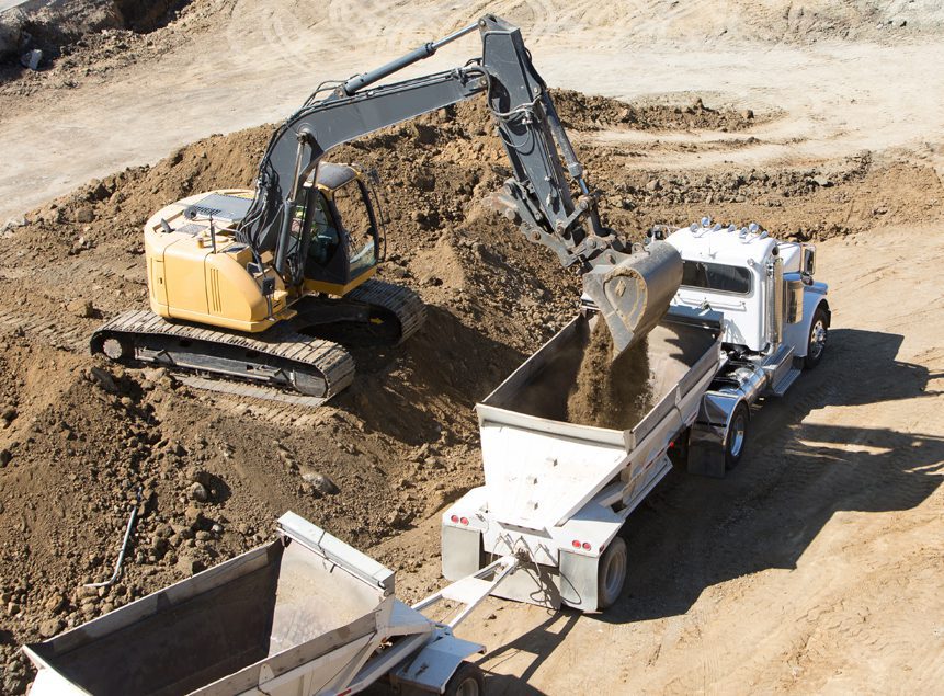 Contractors Resource | Early Branch, SC | Yellow dozer loading dirt into the back of a white truck