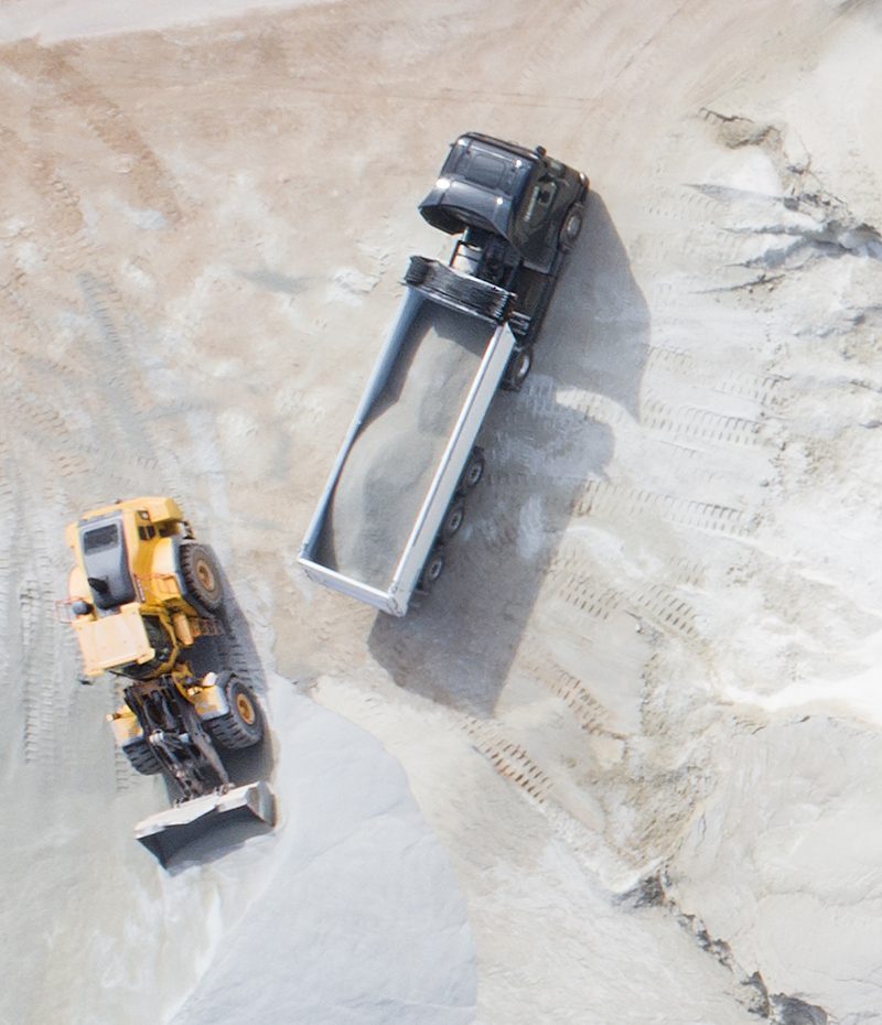 Contractors Resource | Early Branch, SC | Yellow bulldozer scooping up sand next to a black truck filled with sand